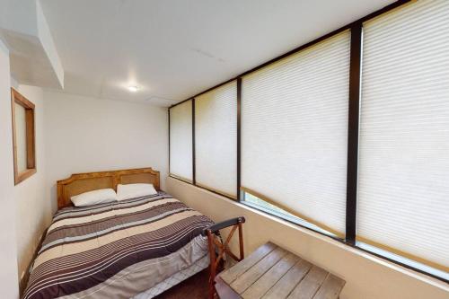 a bedroom with a bed and some windows at Royal Queen Suite Pool-Spa Ski-in out Gym, Sauna, Laundry, BBQ in Brian Head