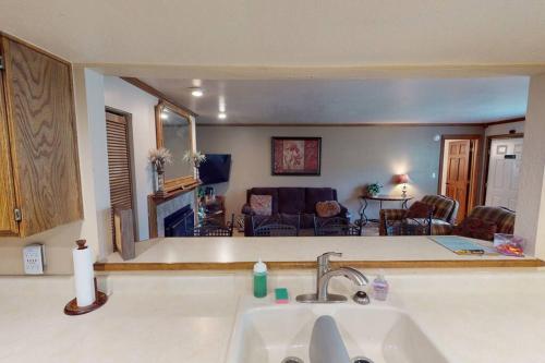 a kitchen with a sink and a living room at Royal Queen Suite Pool-Spa Ski-in out Gym, Sauna, Laundry, BBQ in Brian Head