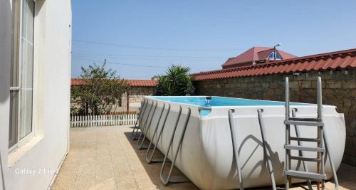 a bath tub sitting on the side of a house at Pine house in Gürgan