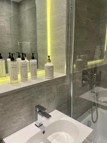 a bathroom with a sink and a shower and a mirror at Superior Large Suite Luxury Living City Apartment, 2 Kingsize Bedrooms Business Suite - Free WiFi in St. Albans