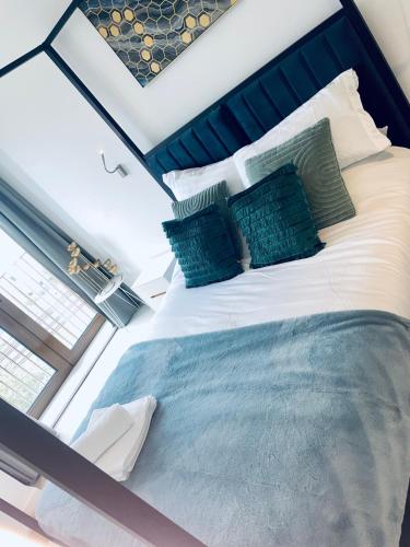 a bedroom with a large bed with a blue headboard at Superior Large Suite Luxury Living City Apartment, 2 Kingsize Bedrooms Business Suite - Free WiFi in St. Albans