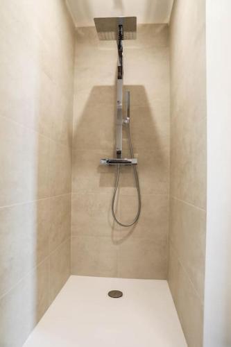 La salle de bains est pourvue d'une douche avec une lumière sur le mur. dans l'établissement Haut de villa vue mer panoramique sur Golfe de Saint-Tropez, aux Issambres