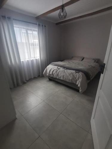 a bedroom with a bed and a window at Shekinah at Sea in Kleinmond