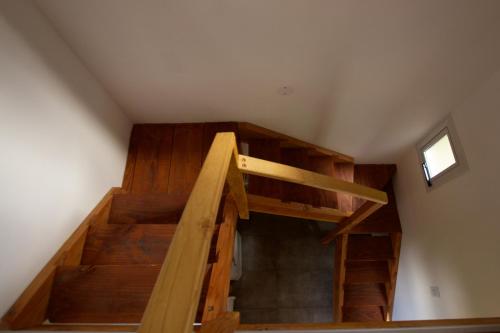a wooden staircase in a attic with a window at Cabañas Casiopea Lago Puelo in Lago Puelo