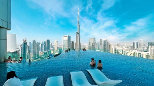 a infinity pool with a view of a city at 5 Star High Rise Luxury Apartment, Infinity Pool With Stunning Burj View - Brand New Apartment in Dubai