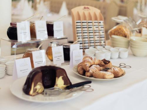 a table with plates of bread and pastries on it at Schloss Thalheim in Sankt Pölten