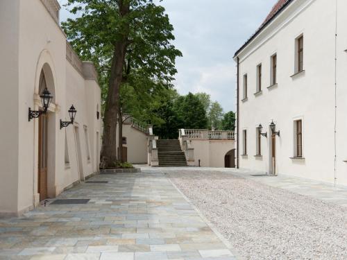 an empty street between two white buildings at Schloss Thalheim in Sankt Pölten