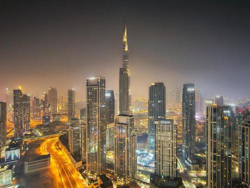 eine große Stadt in der Nacht mit vielen hohen Gebäuden in der Unterkunft 5 Star High Rise Luxury Apartment, Infinity Pool With Stunning Burj View - Brand New Apartment in Dubai