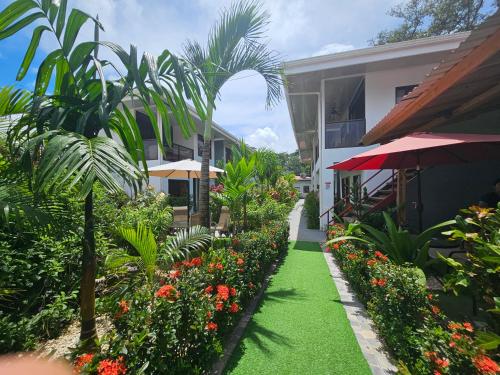a walkway in front of a building with flowers at Ballena Rey Hotel in Uvita