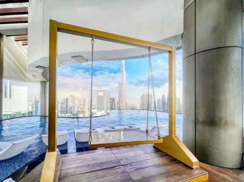 a swing in a room with a view of the city at 5 Star High Rise Luxury Apartment, Infinity Pool With Stunning Burj View - Brand New Apartment in Dubai