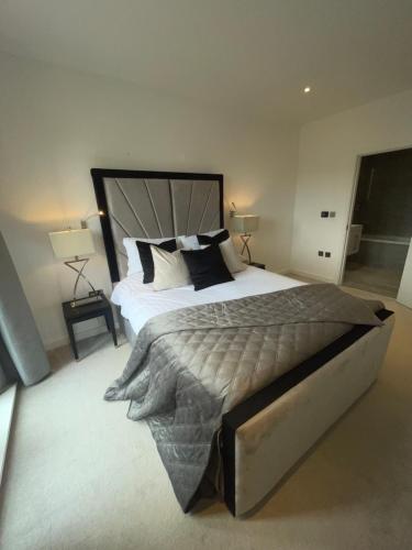 a bedroom with a large bed and two lamps at Superior Large Suite Luxury Living City Apartment, 2 Kingsize Bedrooms Business Suite - Free WiFi in St. Albans