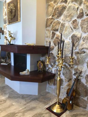 a living room with a fireplace with a violin and a table at Balcony With A View in Nafplio