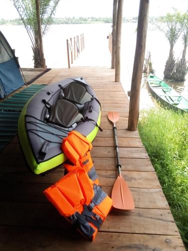a boat with an oar and a paddle on a dock at Glamping Lakeview Ouidah in Gakpé