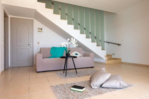 a living room with a couch and a staircase at Al Mare Villas in Kiotari