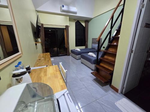 a kitchen with a sink and a living room with stairs at Khumkatang Resort & Restaurant in Ban Bang Rong