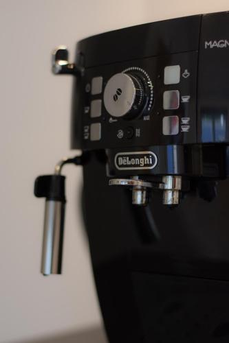 a black coffee machine with a cup attached to it at Krok in Värmdö