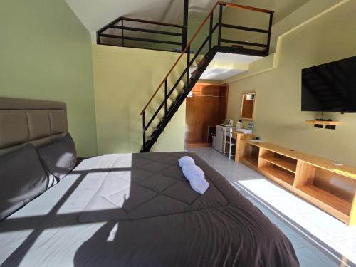 a bedroom with a bed with a television and a staircase at Khumkatang Resort & Restaurant in Ban Bang Rong