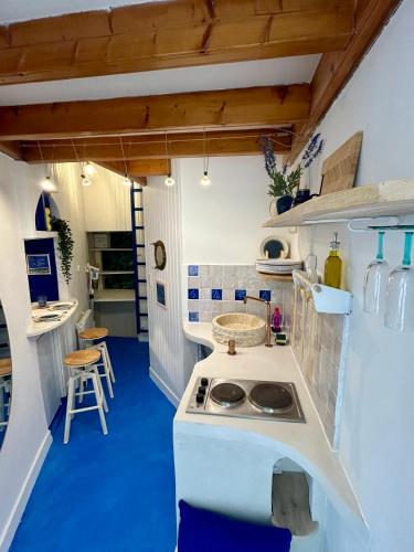 une cuisine avec un comptoir blanc et un sol bleu dans l'établissement Gaïa, à Vannes