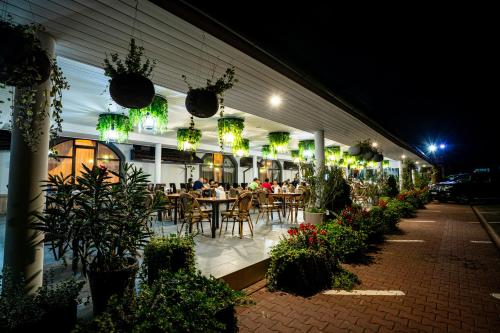 a restaurant with people sitting at tables at night at Hanul Domnesc Imperial Hotel & SPA in Călan