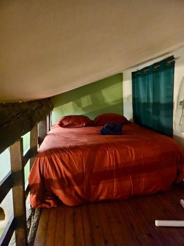 une chambre avec un lit avec une couette rouge dans l'établissement Studio Cosy au Coeur de Narbonne, à Narbonne