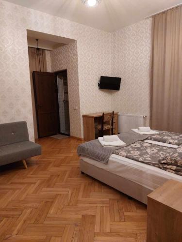 a bedroom with a bed and a chair and a television at Eco Oasis in Surami