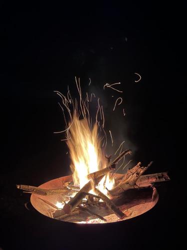 a fire in a bowl with sticks on it at Tranquil Tigín - your Little Holiday in Wicklow in Wicklow