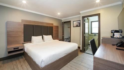 a bedroom with a white bed and a desk and a desk at Americas Best Value Inn, Antioch in Antioch