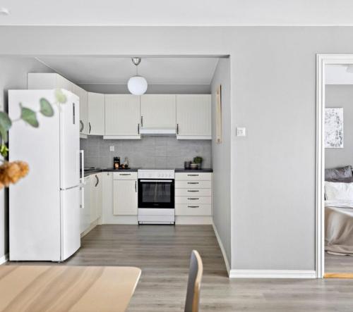 a kitchen with white appliances and a white refrigerator at Topp leilighet i Oslo,Gratis parkering,balkong med utsikt in Høybråten