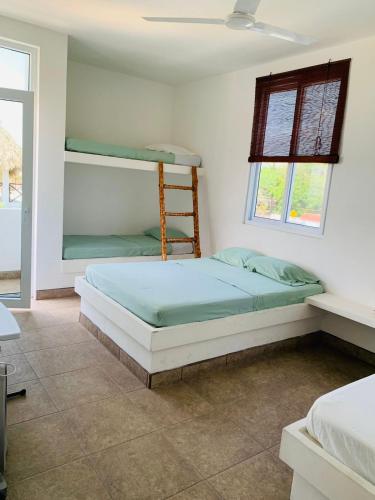 a bedroom with two bunk beds and a window at Casa Caracola in Hawaii