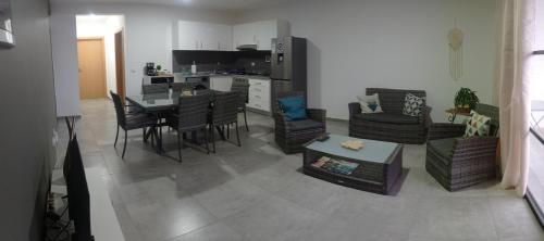a living room with a table and chairs and a kitchen at Tity Apartments T2- Santa Maria in Santa Maria