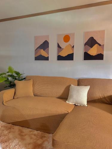 a couch in a living room with paintings on the wall at Vibin Chill Staycation in Manila