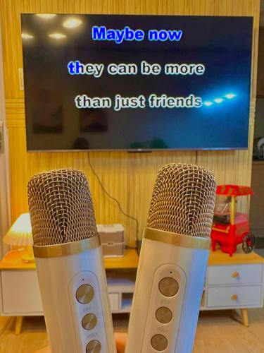two microphones sitting in front of a tv at Vibin Chill Staycation in Manila