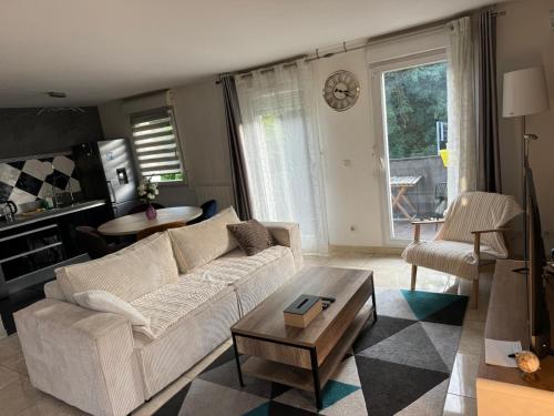 a living room with a white couch and a table at Appartement duplex T3 avec box - Paris - La Défense - Airport CDG - Parc des expositions - Stade de France - Disney - Astérix - Val D Europe in Villepinte