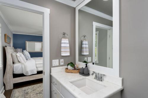 a bathroom with a sink and a bedroom with a bed at Peace of Happiness Coastal Cottage 7 mi from Wrightsville Beach, NC in Windemere