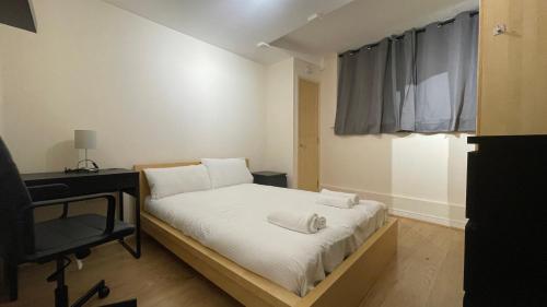 a small bedroom with a bed and a television at 4- bedroom , 1 living room Apartment Near Emirates Stadium in London