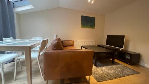 a living room with a couch and a table at 4- bedroom , 1 living room Apartment Near Emirates Stadium in London