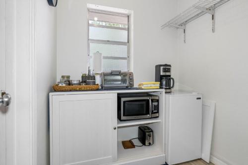 a kitchen with a microwave on a white refrigerator at St Pete Boho Getaway Walk to Pier and Beach in St. Petersburg