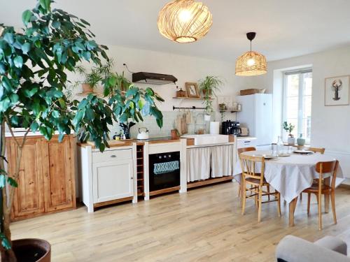 une cuisine et une salle à manger avec une table et des chaises dans l'établissement Le Pré de la Mer Le Gîte, à Urville-Nacqueville
