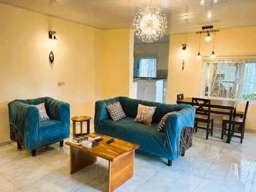 a living room with a blue couch and a table at Exclusive Boutique Style Villa in Freetown