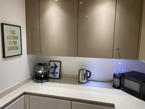 a kitchen with a counter top with a microwave at Luxury Apartment in Olympic Village in London