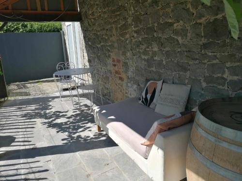 a bed sitting on a patio next to a building at Une Cabane au Verger in Anthisnes