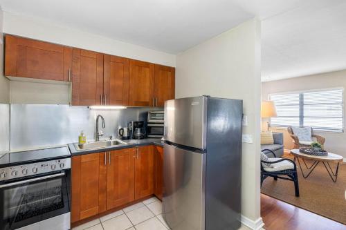 a kitchen with a stainless steel refrigerator and wooden cabinets at Perfect Location Vinoy Beach Getaway Sun and fun in St. Petersburg