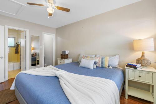 a bedroom with a blue bed with a ceiling fan at Perfect Location Vinoy Beach Getaway Sun and fun in St. Petersburg