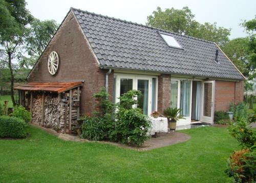 a small brick house with a grass yard at Koetshuis Bothalenshof in Malden