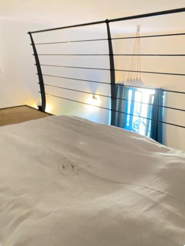 - un lit blanc avec une tête de lit en métal dans l'établissement Hypercenter Lyon, à Fourvière