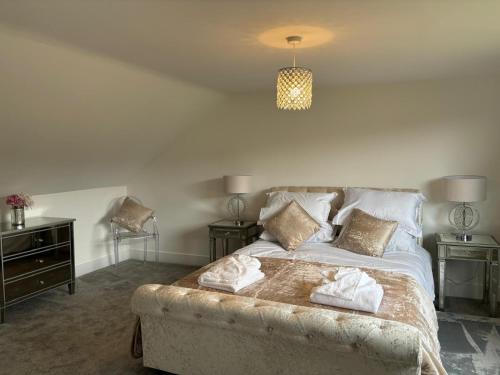 a bedroom with a bed with two towels on it at Newly Refurbished Tor View Executive Dormer Bungalow Rossendale in Haslingden