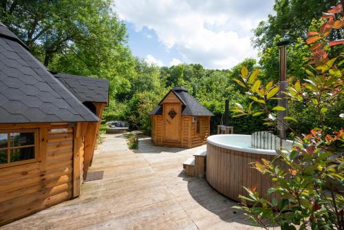 une arrière-cour avec un bain à remous et une maison en bois dans l'établissement La Bulle de Chantilly - Spa & sauna privatifs & petit déjeuner gourmand, à Saint-Leu-dʼEsserent