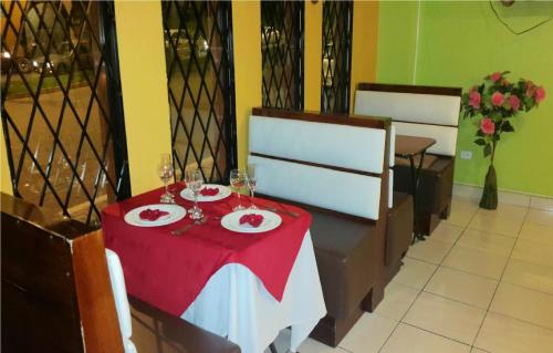 a table with a red table cloth and wine glasses at Hotel Gran Quitumbe in Quito