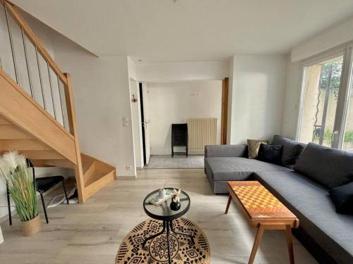 a living room with a couch and a table at Maison familiale avec extérieur in Clermont-Ferrand