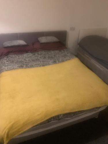a bed in a small room with a yellow blanket at The retreat in Nottingham